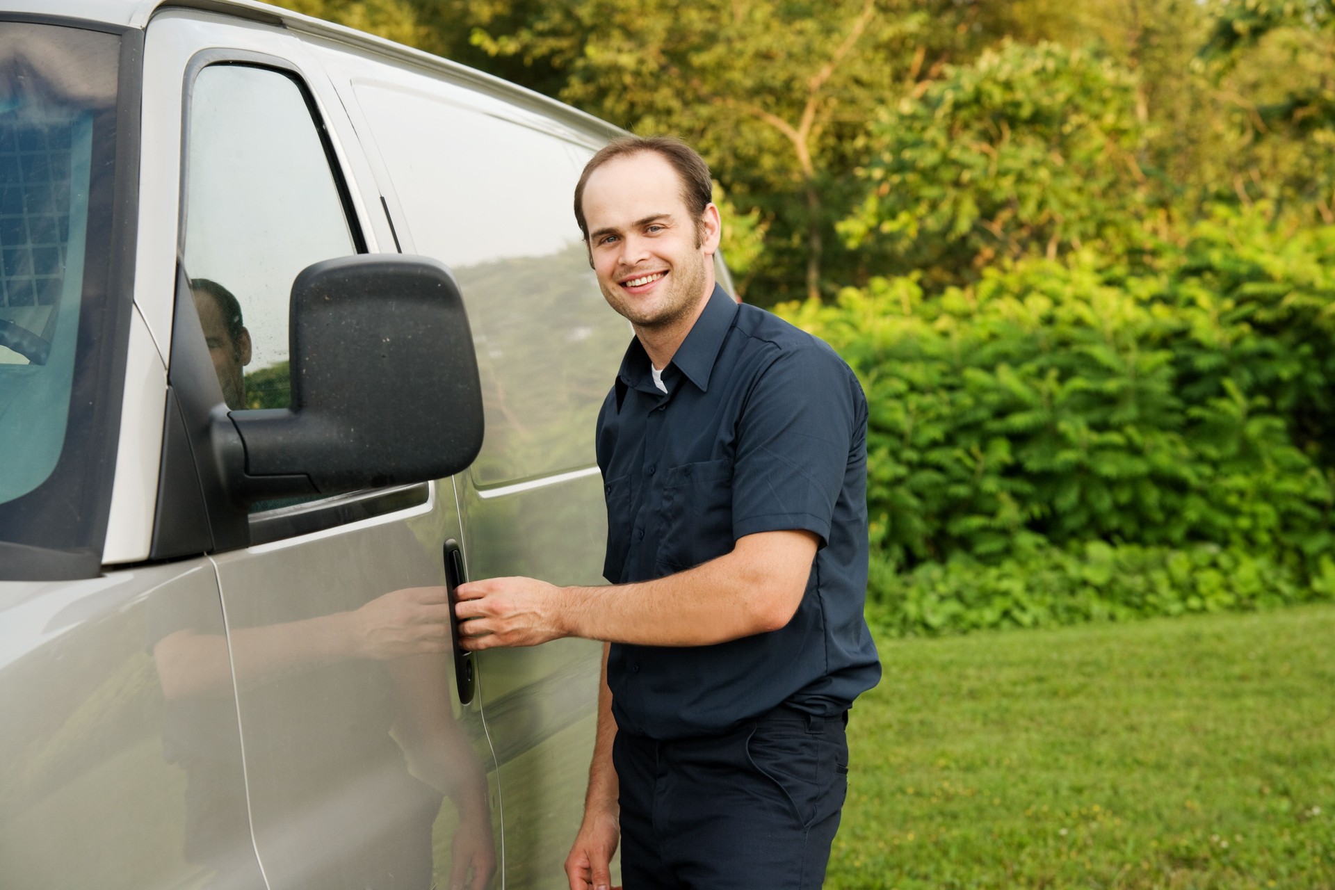 Man in Industrial Uniform Standing Next to Service Van